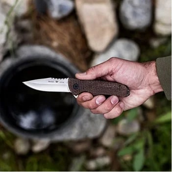 Folded pocket knife on rugged wood backdrop